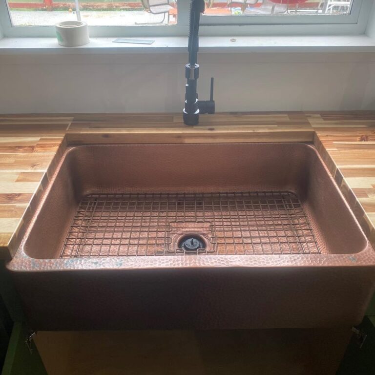 certified plumbers near me copper sink installed in a butcher block counter with black finished faucet